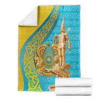Golden and teal throw blanket with warrior graphic, with folded white towels