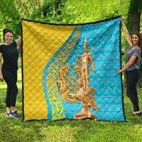 Large gold and blue quilt with central gold statue motif and decorative edging.