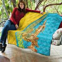 Gold and blue quilt laid on patio seating, showing gold statue and patterned panel.