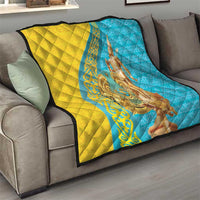 Gold and blue quilt draped over a sofa, with gold statue artwork on the center.