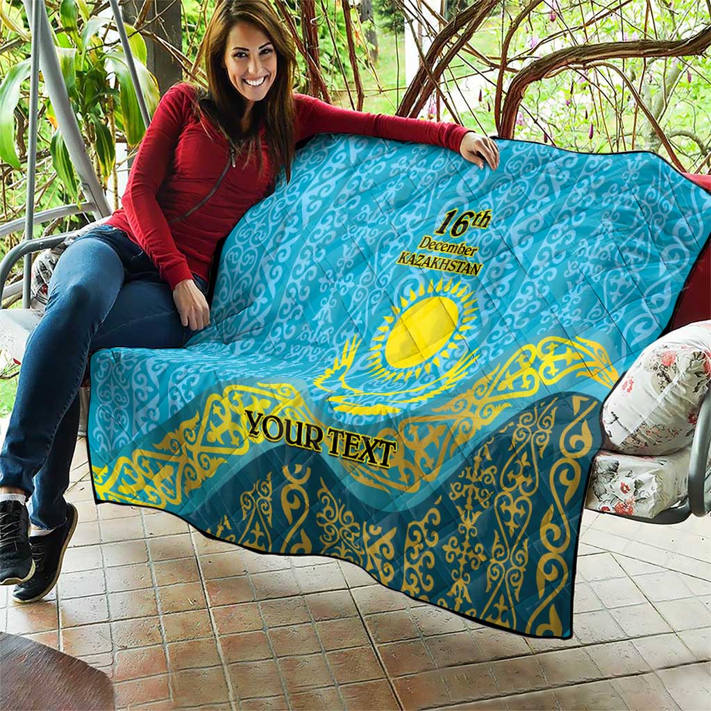 Blue quilt held up outdoors with yellow Kazakh emblem, “16th December Kazakhstan,” “YOUR TEXT”