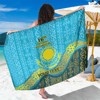 Personalized blue sarong with Kazakh pattern, circular emblem and 'YOUR TEXT' print
