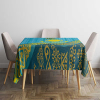 Teal-blue tablecloth with gold swirl ornament pattern over square dining table