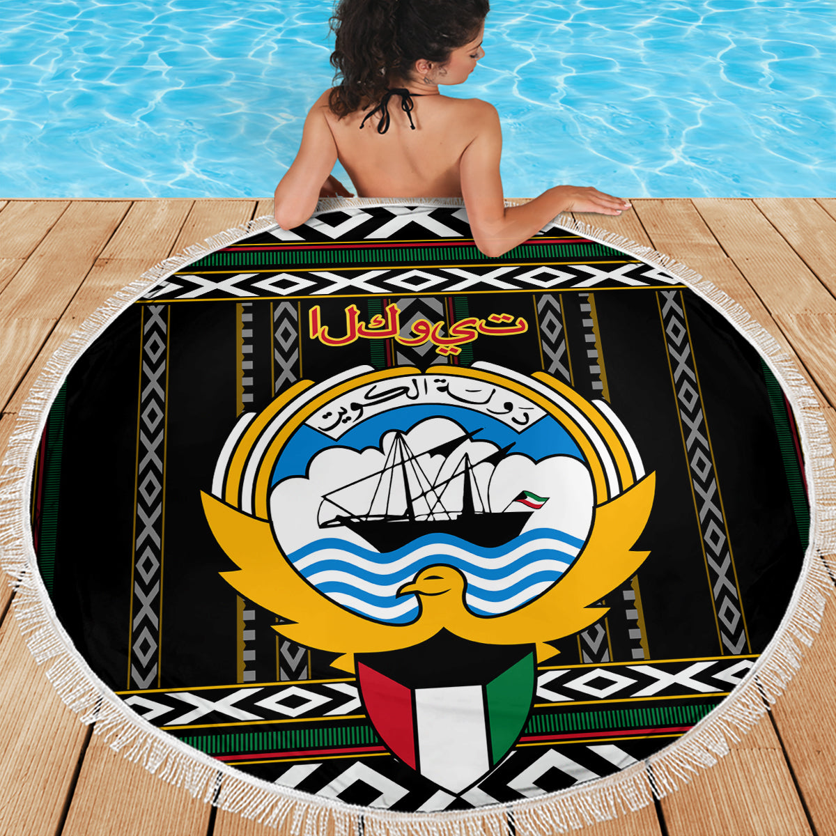 Round beach blanket with Kuwait hawk emblem and bold geometric Al Sadu trim, fringed edge