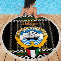 Round beach blanket with Kuwait hawk emblem and bold geometric Al Sadu trim, fringed edge