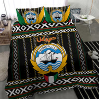 Black bedding set with large central emblem print, green trim, and repeating diamond stripes