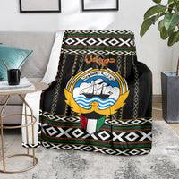 Black patterned personalized blanket with central crest emblem and striped geometric bands.