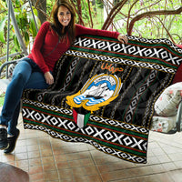 Personalized quilt draped on sofa with central emblem and black-white geometric bands