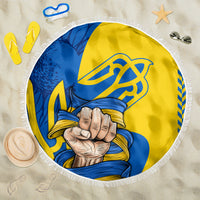 Round beach blanket with blue and yellow trident fist graphic and white fringed edge