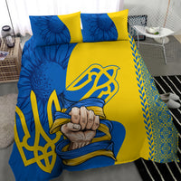 Blue and yellow duvet and pillows with trident emblem, fist-in-scarf motif, and ornate edge