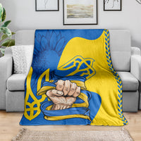 Throw blanket in blue and yellow with trident emblem and folk clasped hands artwork