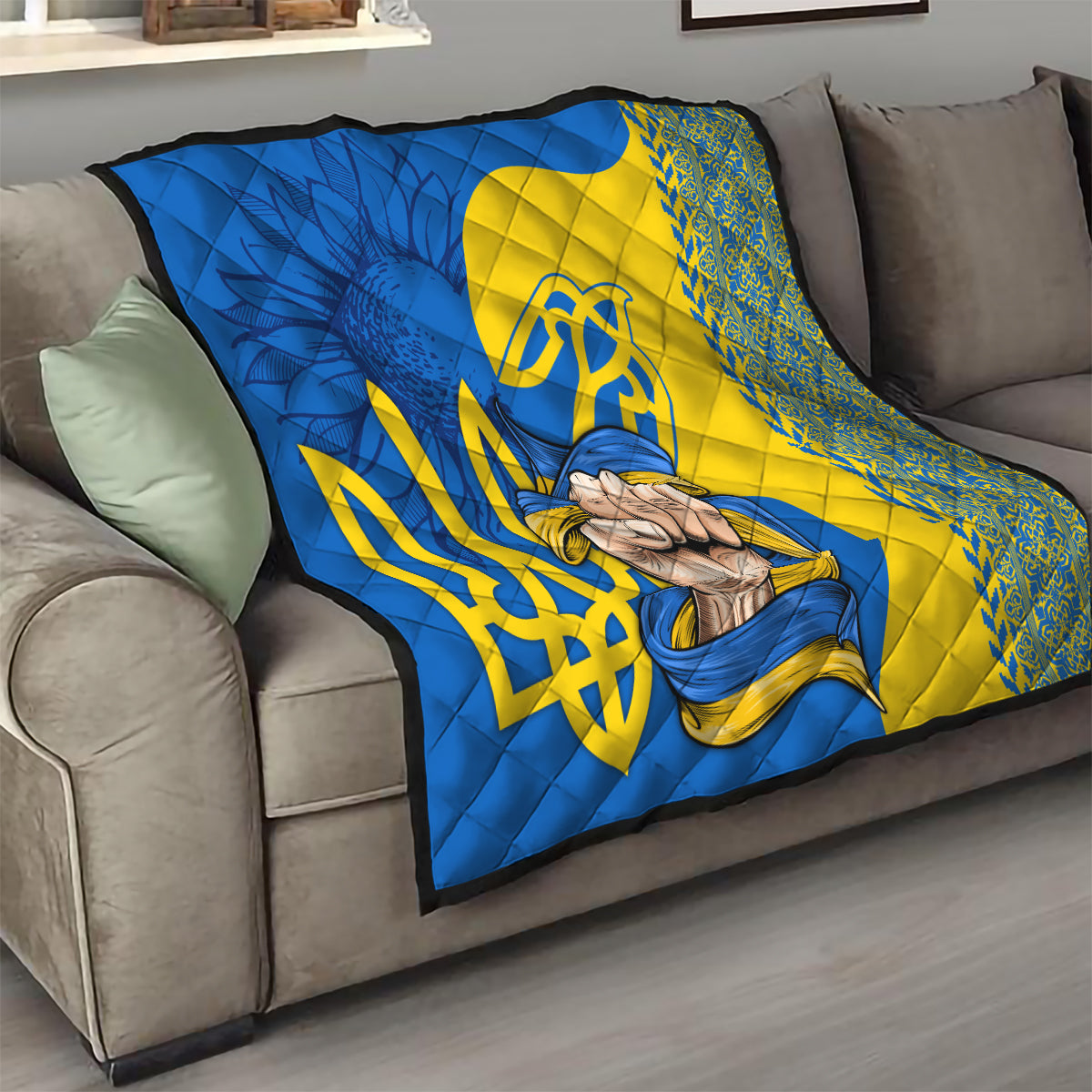 Personalized throw quilt on sofa with blue and yellow Ukrainian emblem, trident, and hands