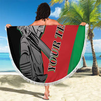 Person holds round fringe beach blanket showing cricket player art on red, green, and black