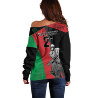 Black off-shoulder sweater with green-red panel and cricket player graphic, long sleeves
