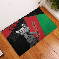 Cricket rubber doormat angled on floor, black, red, and green player graphic with custom text