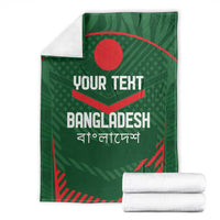 Green Bangladesh cricket blanket with custom text, folded with stacked white rolls.