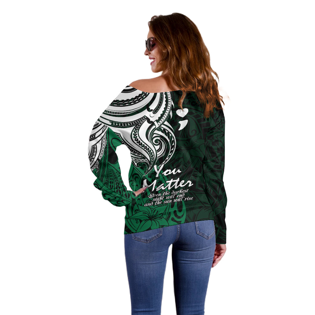 Women's off-shoulder green sweater back/side view with white tribal scroll pattern
