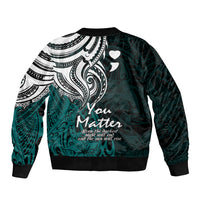 Unisex bomber jacket with black-and-white tribal panel, turquoise base, heart accents, ribbed cuffs