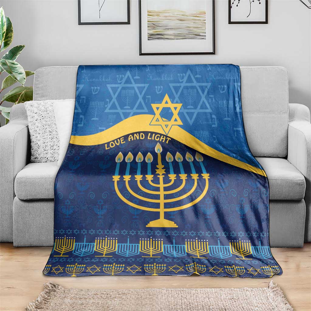 Blue Hanukkah blanket draped on a couch with gold Star of David and menorah 'Love and Light'