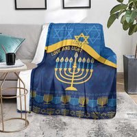 Blue Hanukkah blanket spread over a couch, showing gold Star of David and menorah pattern