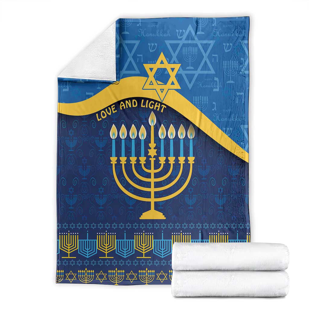 Folded blue Hanukkah blanket with gold Star of David and menorah, 'Love and Light' text, with towels