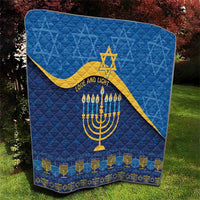 Blue Hanukkah quilt with quilted texture, yellow Star of David, menorah, and candle motifs