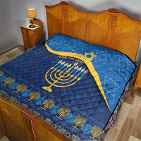 Blue Hanukkah quilt on bed showing yellow Star of David and menorah with 'LOVE AND LIGHT'