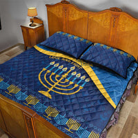 Blue quilt bed set with gold Hanukkah symbols and geometric patterned trim, two pillows