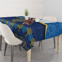 Blue Hanukkah tablecloth on a dining table, featuring gold menorah and star accents