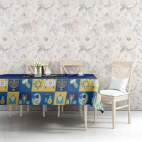 Blue Hanukkah-themed tablecloth with menorah and candle icons in patchwork blocks