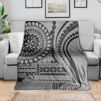 Black siapo art throw blanket draped on a sofa, with bold tribal patterns and arches