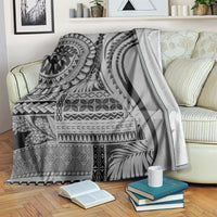 Black siapo art throw blanket over a striped sofa, with bold tribal blocks and swirls