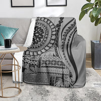 Black siapo art throw blanket over a couch, showcasing tribal panels and curved motifs