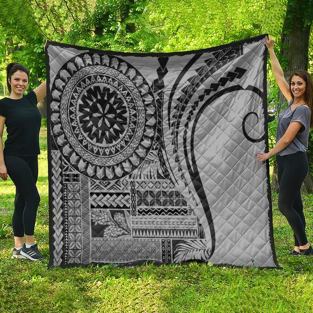 Black and white geometric quilt with circular mandala and crescent moon, fully spread