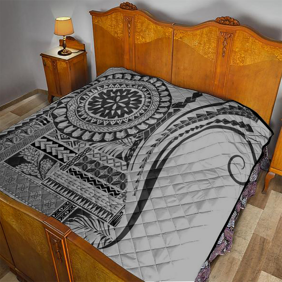 Black and white geometric quilt with mandala center and quilted crescent on bed