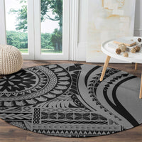 Round black and gray tribal patterned rug on hardwood floor