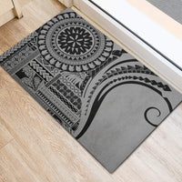 Black rubber doormat with large gray circular motif and geometric print, close view