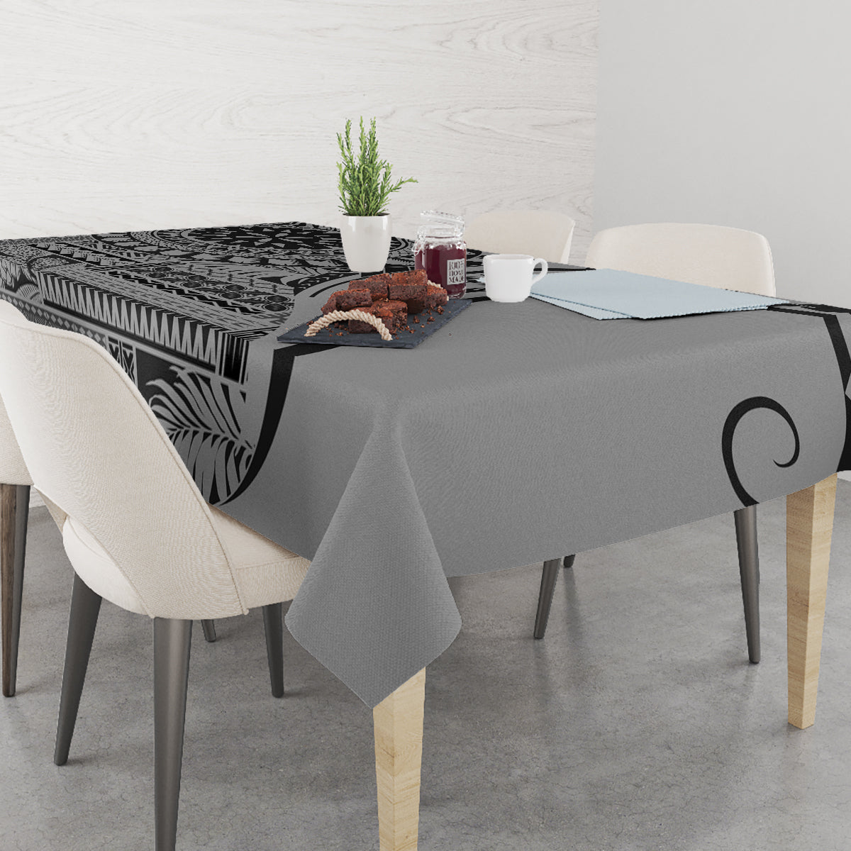 Black art tablecloth with leaf and tribal geometric print, draped over dining table