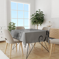 Black art tablecloth with gray leaf motif and circular swirl, on dining table in room