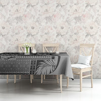 Black and gray patterned art tablecloth on dining table with chair and floral wall decor
