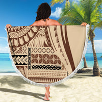 Round fringed beach blanket with brown geometric pattern, held open on beach