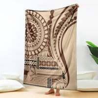 Brown and cream geometric art blanket with circular and wave motifs, draped on floor