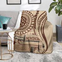 Brown and cream geometric art blanket draped over sofa, with circular and striped motifs