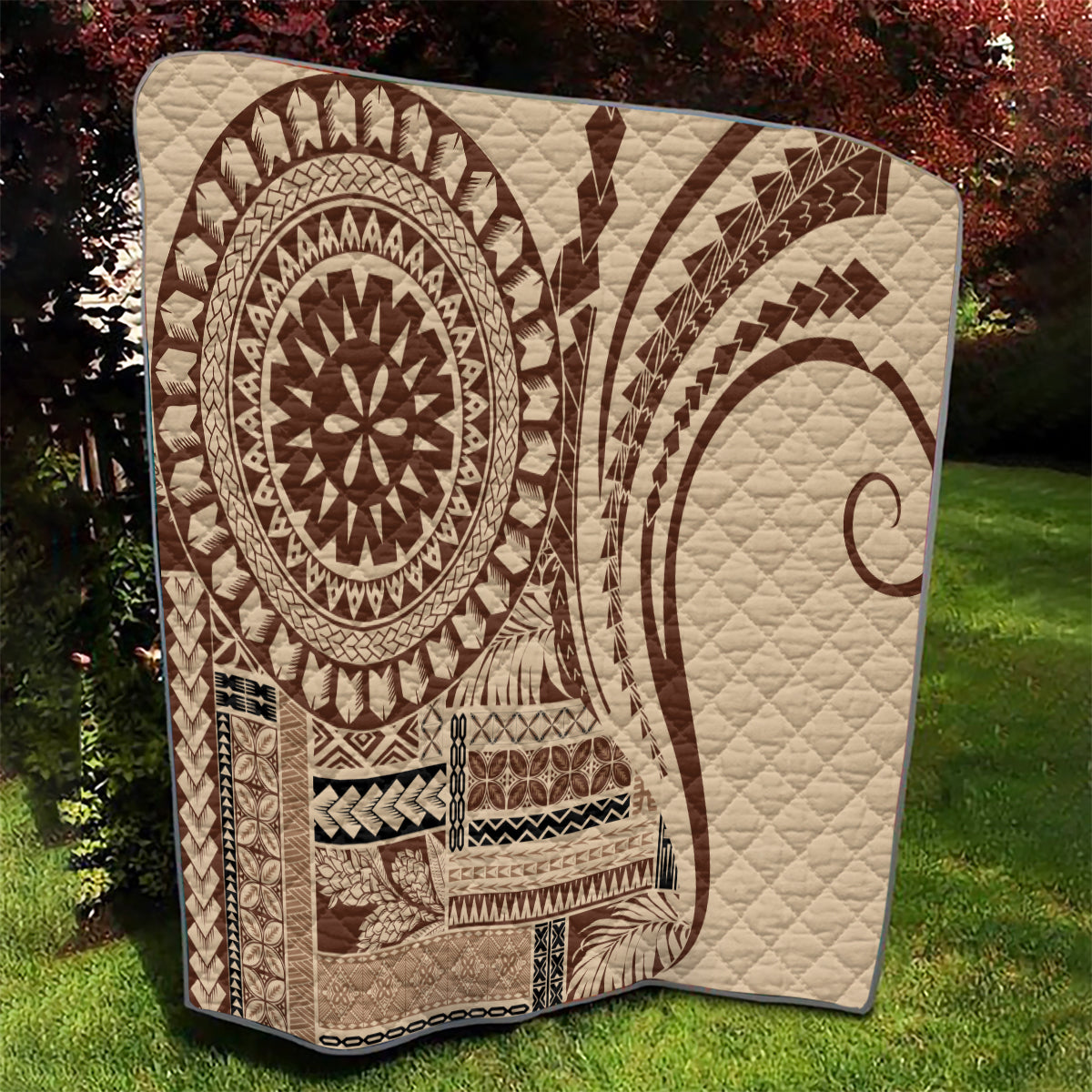 Brown Samoa Siapo-style quilt showing quilted fan and oval sun motifs on outdoor ground