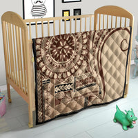 Brown and cream Samoa Siapo-style quilt with oval sun medallion, tucked in baby bed