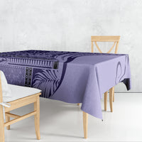 Purple patterned tablecloth draped over a dining table with a deep folded edge