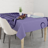 Purple patterned tablecloth on a dining table with small centerpiece items