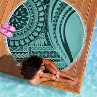 Round turquoise patterned beach blanket with white fringe, laid flat