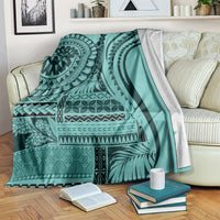 Turquoise patterned blanket spread on couch with black mandala and leaf designs