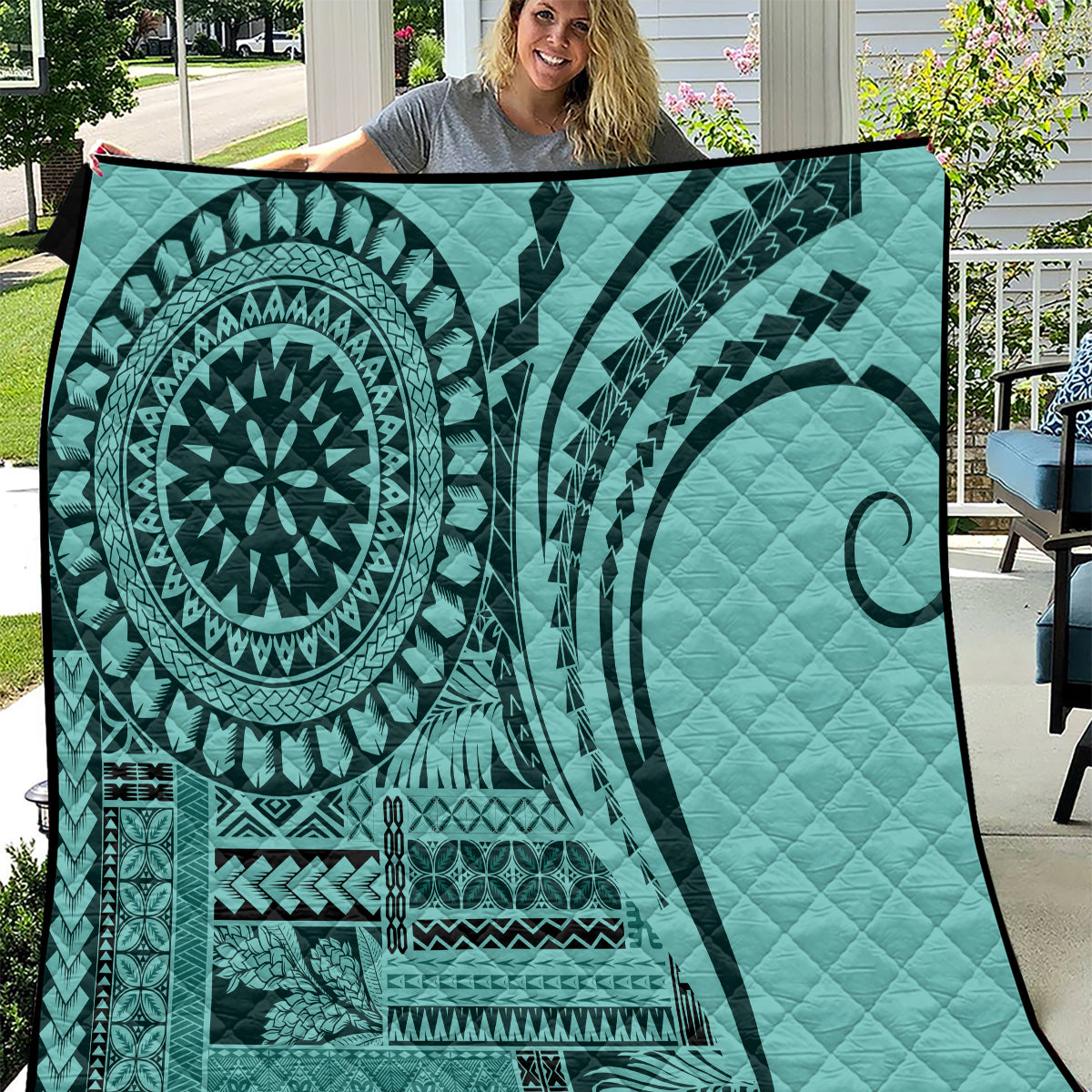 Turquoise quilt with bold circular mandala and tribal stripe patterns, quilted texture